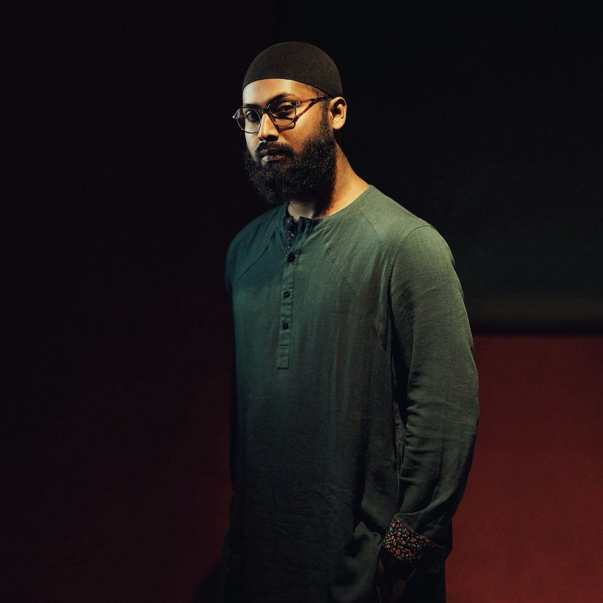 Man wearing a dark cap and a green kurta